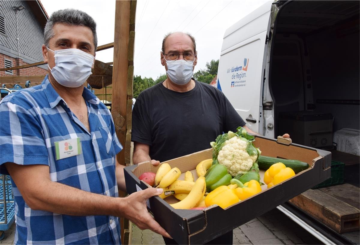 Tafel-Mitarbeiter Valid Ahmad (links) und Peter Schnapka holen Lebensmittel vom Markankt-Markt in Ellwürden ab.