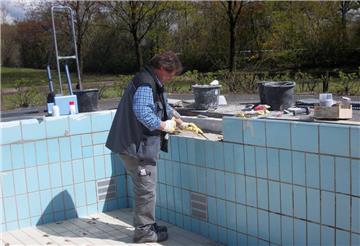 Die Vorbereitungen für die Eröffnung am 21. Mai laufen. Frank Riethmüller ersetzt einige Fliesen im Lubibad. Sie sind nur noch schwer zu bekommen und müssen mit Kleber repariert werden. Inzwischen ist das Becken mit Wasser gefüllt.  Foto Plesse