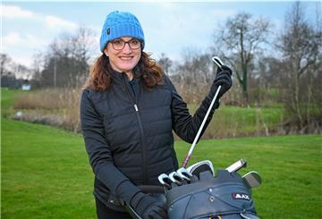 Eine Frau mit einem Golfschläger in der Hand.