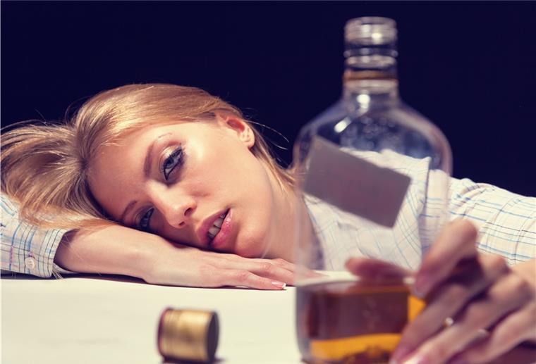 Eine Frau  mit einer Flasche Alkohol. 