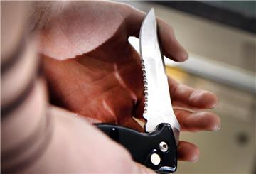 Klinge eines Klappmessers in einer Hand.