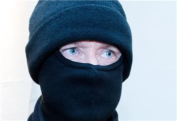 Ein als Einbrecher verkleideter Mann trägt eine Maske.