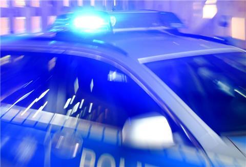  Ein Streifenwagen der Polizei steht mit eingeschaltetem Blaulicht auf der Straße