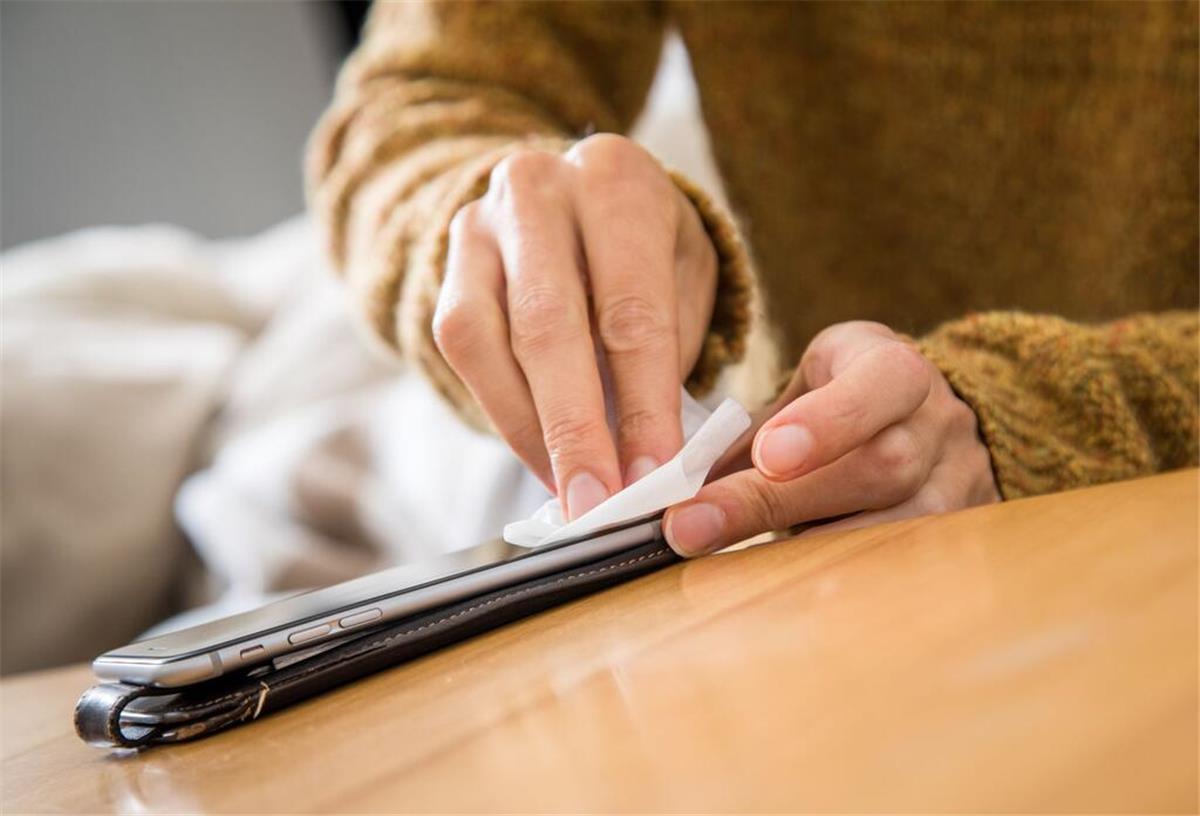 Warum Glasreiniger & Co. für Smartphones tabu sind Ein Mensch macht sein Handybildschrim sauber.