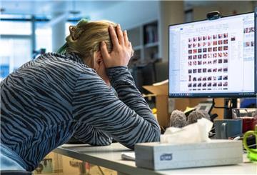 Eine Frau sitzt verzweifelt vor einem Monitor. 