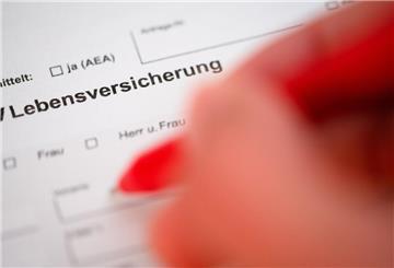 Eine Person füllt mit einem Kugelschreiber einen Antrag für das Abschließen einer Lebensversicherung aus.