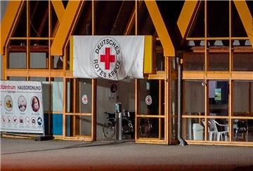 Eine Rot-Kreuz-Fahne hängt über dem Eingang zum Impfzentrum in Eich. 
