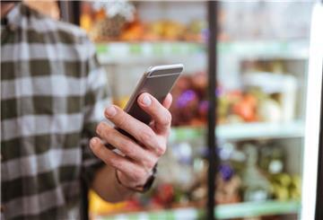 Mann im Einkaufsmarkt Smartphone