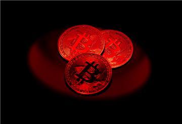 Bitcoin-Münzen liegen auf einem Tisch in rotem Licht. Digitale Münzen können hohe Gewinne bringen – aber auch Totalverluste. Wer Krypto kauft, trägt selbst die Verantwortung für Sicherheit und Auswahl.