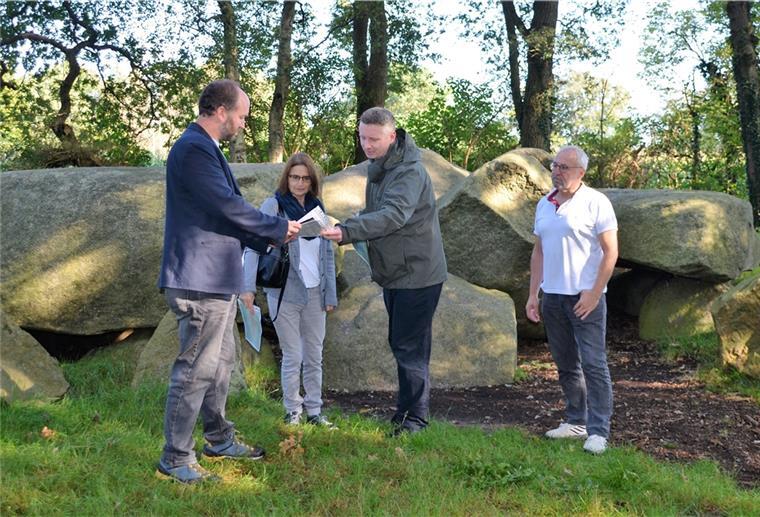 Geschichte pur: Geestland hat jetzt einen „Denkmalatlas“ Vier Menschen vor einem Großsteingrab
