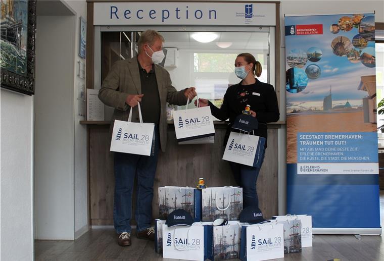 Bremerhaven: „Sail“-Andenken werden gespendet Dr. Ralf Meyer übergibt Hotelmanagerin Ann-Christin Heins von der Seemannsmission Sail-Souvenirs, um die dort betreuten Seeleute zu erfreuen.