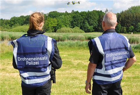 Zwei Polizisten fliegen eine Drohne.