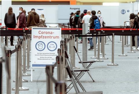 Menschen stehen im Impfzentrum Messehallen an, um sich gegen das Corona-Virus impfen zu lassen.