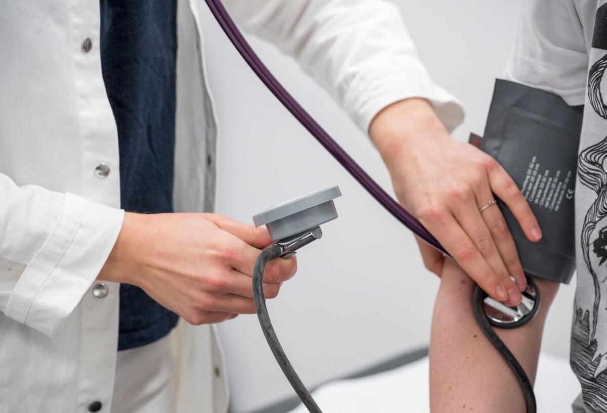 Kontaktgebühr beim Arztbesuch: Millionen Patienten müssten extra zahlen! Arzt kontrolliert den Blutdruck und den Puls eines Patienten.