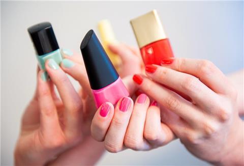 Mehrere verschiedene Sorten Nagellack werden in Händen gehalten.