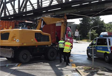 Ein Bagger hängt unter einer Brücke fest.