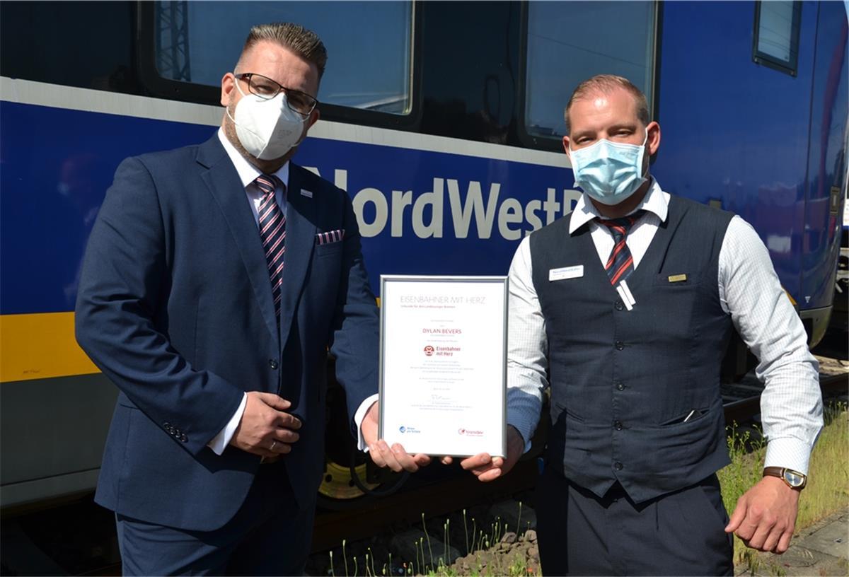 Dylan Bevers (rechts) bekommt die Auszeichnung für den Landessieg von Robert Palm, Regionalleiter der Regio-S-Bahn Bremen/Niedersachsen und des Weser-Ems-Netzes, überreicht.