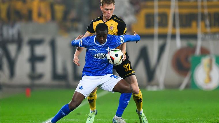 Dynamos Jonas Sterner spielt gegen Darmstadts Merveille Papela den Ball mit der Hand.