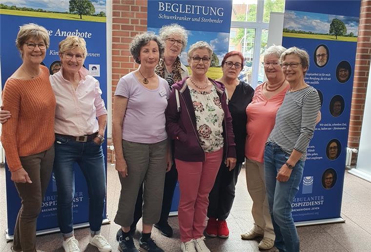 Ehrenamtliche aus der Zevener Gruppe, die die Ausstellung mitgestaltet haben, stehen im Foyer des Zevener Rathauses vor den Tafeln.