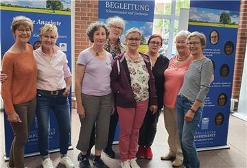Ehrenamtliche aus der Zevener Gruppe, die die Ausstellung mitgestaltet haben, stehen im Foyer des Zevener Rathauses vor den Tafeln.