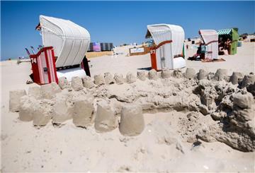 Zahlreiche Strandkörbe stehen bei sonnigem Wetter hinter einer Sandburg am Strand der Insel. Eigentlich ist die Insel das Erlaubsparadies an der Nordseeküste. Doch bei Hundebesitzern sinkt die Gunst der Insel. Das hat Gründe.