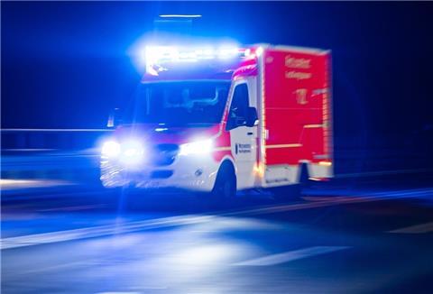 Ein Rettungswagen der Feuerwehr fährt mit Blaulicht durch eine Straße