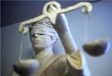 Justizia hält eine Waage in der Hand.