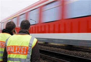 Ein Zug fährt an Polizeibeamten vorbei