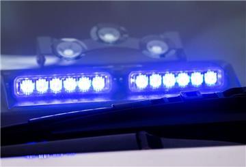Ein Blaulicht leuchtet unter der Frontscheibe eines Einsatzfahrzeugs der Polizei.