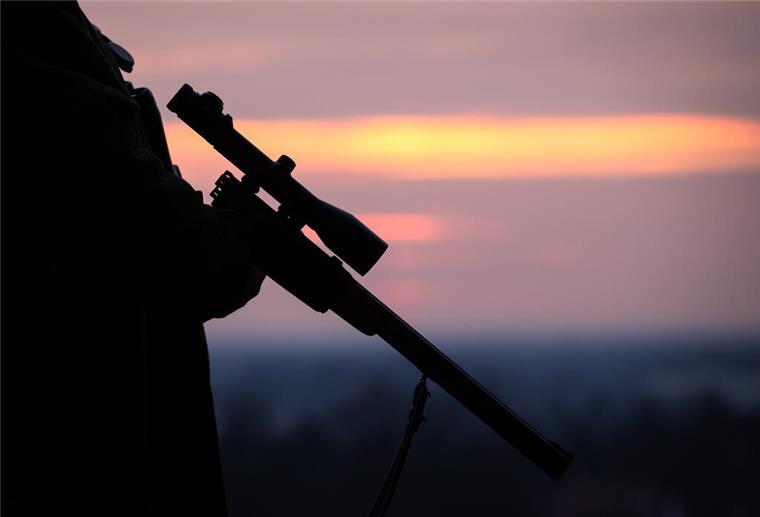 Lamstedt: Jäger schießt auf anderen Jäger und verletzt ihn schwer Ein Jäger hält sein Gewehr in der Abenddämmerung.