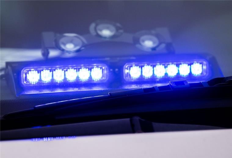 Ein Blaulicht leuchtet unter der Frontscheibe eines Einsatzfahrzeugs der Polizei.