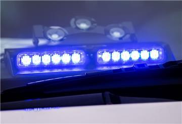 Ein Blaulicht leuchtet unter der Frontscheibe eines Einsatzfahrzeugs der Polizei.