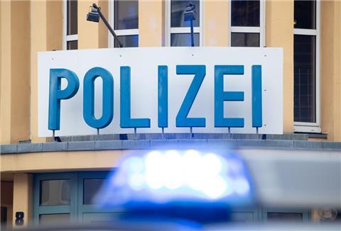 Ein Einsatzwagen der Polizei steht vor einer Dienststelle.