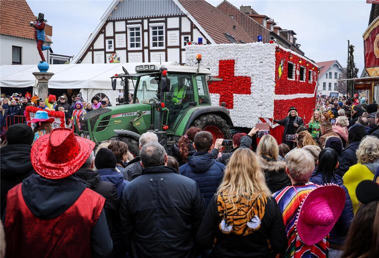 Ein als Krankenwagen geschmückter Karnevalswagen fährt beim Straßenkarnevalsumzug des Dammer Carnevals an der Statue des Dammer Narren (l) vorbei.