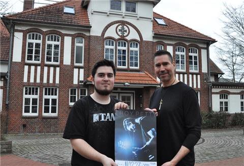 Zwei Männer halten ein Plakat hoch.