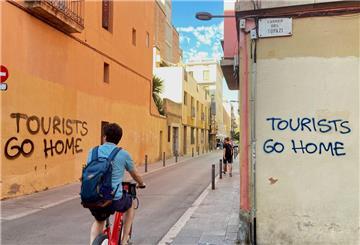 Ein an eine Wand im Künstlerviertel Vila de Gràcia gesprühter Schriftzug „Tourists Go Home“.