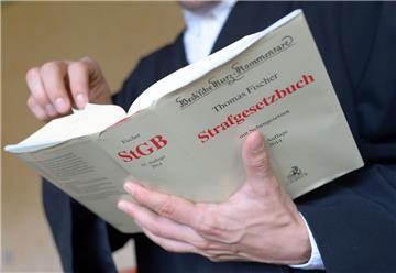 Ein Anwalt steht in einem Verhandlungssaal im Gericht und hält eine Ausgabe des Strafgesetzbuches in Händen. In Zeven wurde am Montag ein Mann aus Wilstedt verruteilt, weil er eine zur Tatzeit 15-Jährige sexuell missbraucht haben soll. 