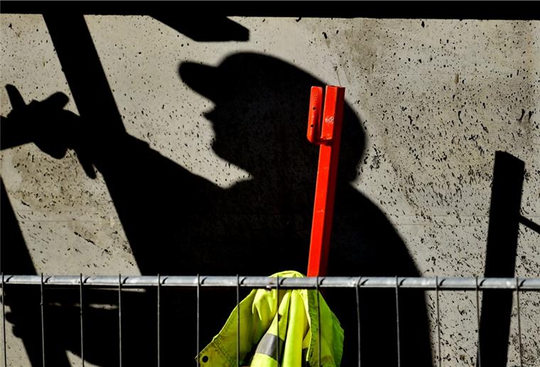 Ein Arbeiter ist auf einer Baustelle beschäftigt und wirft dabei einen dunklen Schatten. Die Wirtschaftsleistung in Deutschland ist im zweiten Quartal in Folge der Corona-Krise erheblich eingebrochen.