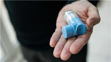 Ein Asthmatiker hält einen Asthmaspray in der Hand.