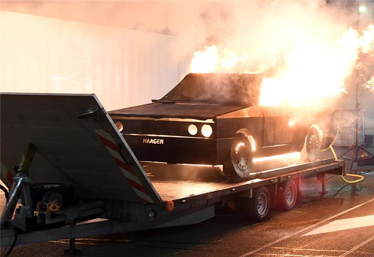 Eine Autoattrappe steht in Flammen.