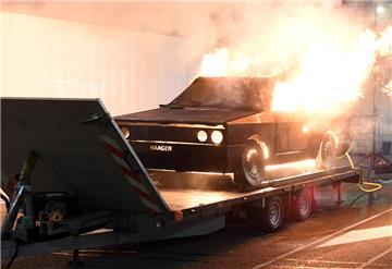 Eine Autoattrappe steht in Flammen.