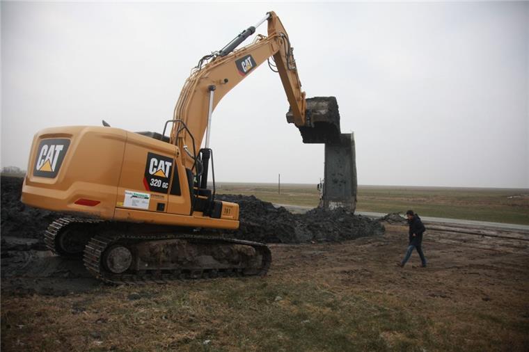 Ein Bagger verteilt den Kleiboden aus Bremerhaven gleichmäßig auf der Außenböschung des Nordseedeiches in Spieka-Neufeld. Ab 2020/21 soll hier der Deich auf einer Länge von 1,7 Kilometern um rund 60 Zentimeter erhöht werden.