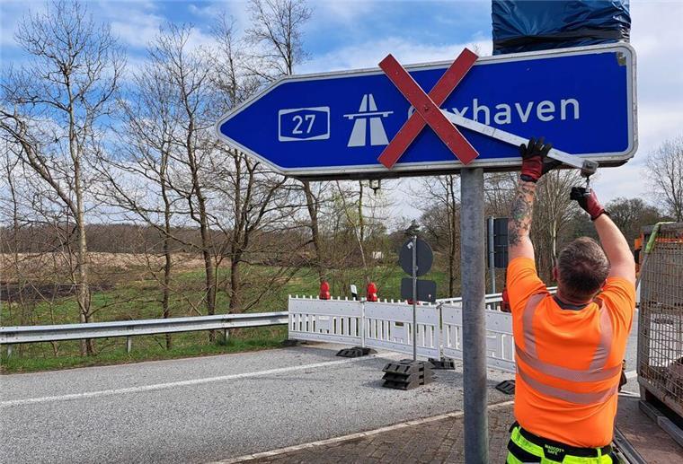 Ein Bauarbeiter entfernt das Gesperrt-Zeichen in Richtung Cuxhaven.
