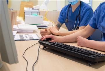 Ärzte sitzen in der Corona-Notaufnahme des Städtischen Klinikum Dresden im Empfangsbereich vor einem Computerbildschirm.