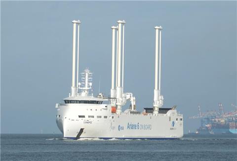 Ein hochmodernes Segel-Frachtschiff mit vier Masten auf dem Wasser.