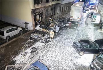 Feuerwehleute sind nach der Chaosfahrt eines Lastwagenfahrers im Einsatz. Ein betrunkener Lastwagenfahrer hatte am Abend des 08.02.2022 nach einem Unfall an einer Kreuzung mit seinem tonnenschweren Gefährt eine Schneise der Verwüstung hinterlassen, Autos gerammt, diese gegen eine Hauswand gedrückt, mehrere Brände und Schäden an einigen Häusern verursacht.