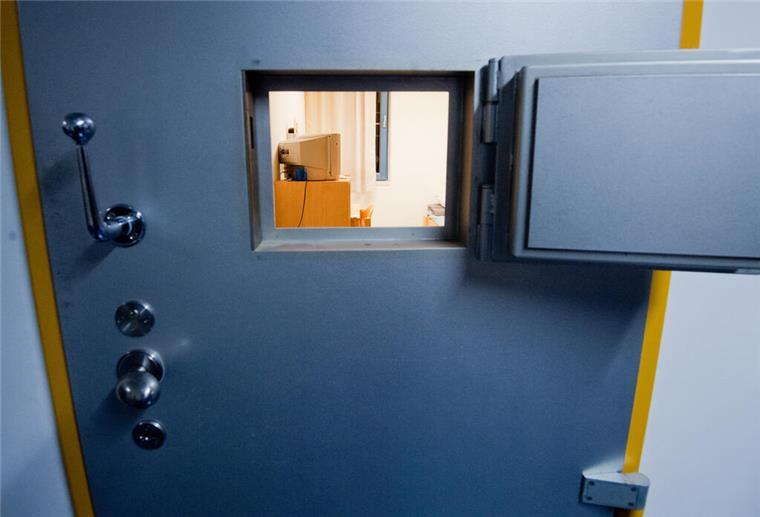 33-Jähriger will ins Gefängnis und steht deshalb vor Gericht Ein kleines Fenster in einer Zellentür gewährt einen Einblick in eine Gefängniszelle.