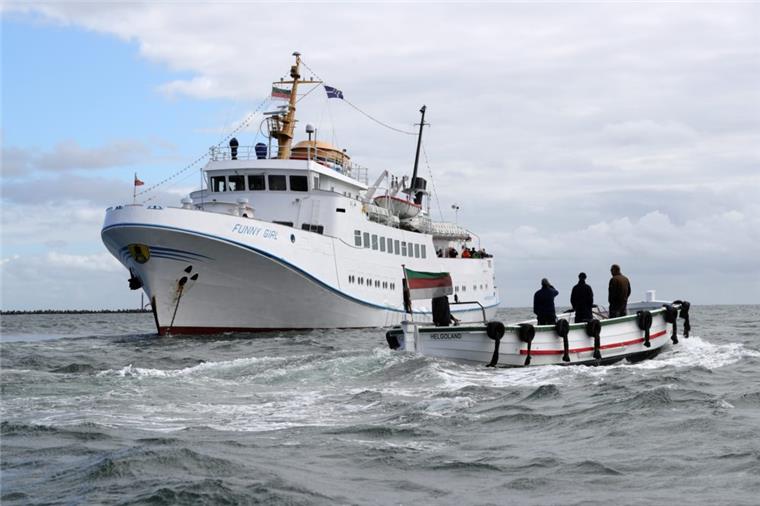 Ein Börteboot ist  auf dem Weg zu dem Ausflugsschiff Funny Girl. Das erste Börteboot mit Elektromotor soll von Mitte Mai an vor Helgoland getestet werden. 