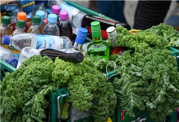 Ein Bollerwagen ist bei einer Kohlfahrt mit Grünkohlblättern und alkoholischen Getränken gefüllt.