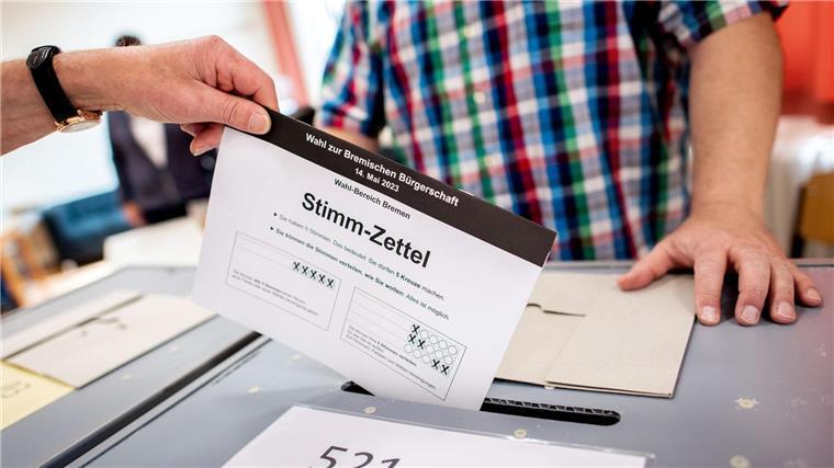 Ein Bürger wirft in einem Wahllokal in eine Wahlurne.